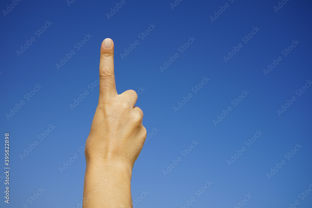 women's hands show the number one against a cloudless blue sky women's hands show the number one against a cloudless blue sky