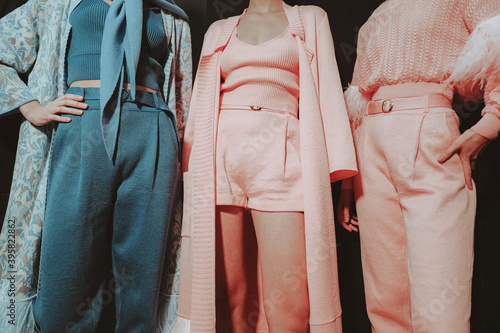 Three cropped female figures in pink and blue stylish elegant clothes on backstage Fashion week photo