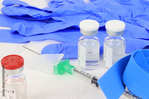 vacuna con viales, jeringuilla, compresor y guantes azules