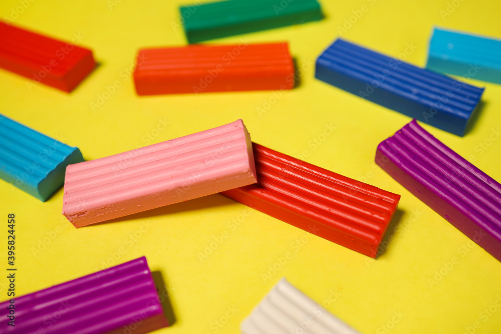 Colorful children's plasticine on a yellow background, colorful clay for modeling the dough Colorful children's plasticine on a yellow background, colorful clay for modeling the dough