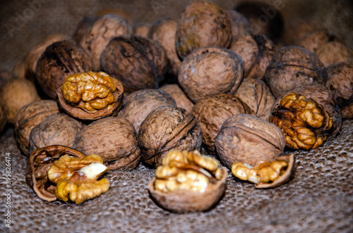 Walnuts, whole and split, lie on a jute background, a useful source of proteins and fats in nutrition