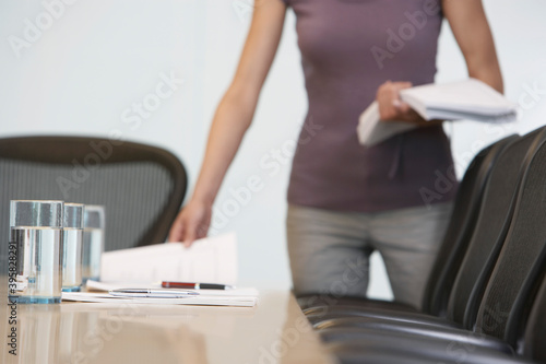 Midsection Of Female Worker Arranged Documents On Conference Table