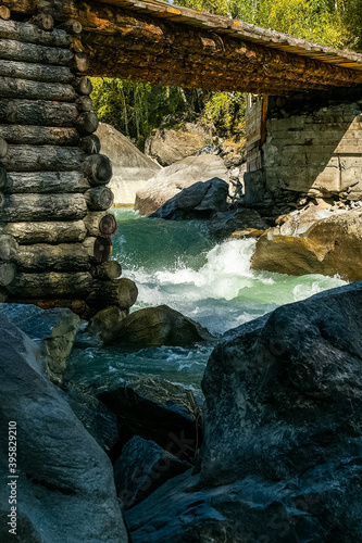 wooden bridge made of logs across a mountain river. photo