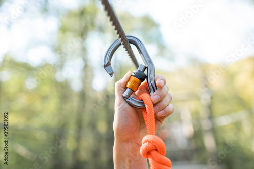 Climber fasten carbine on a rope, close-up