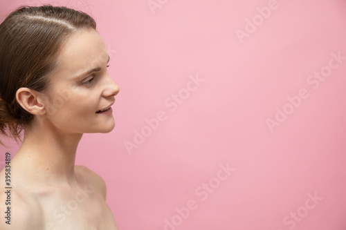 Beautiful sensual topless brunette womanstanding isolated over pink background, posing