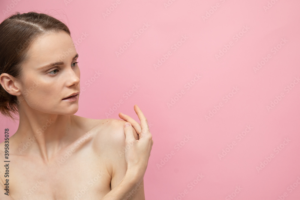 Naklejka premium Beautiful sensual topless brunette womanstanding isolated over pink background, posing