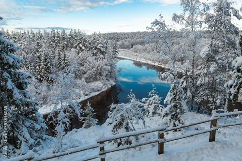Gaujas National park Latvia Gauja river Erglu Cliffs sandstone walls snow covered trees in the winter reflection mirror nor frozen river