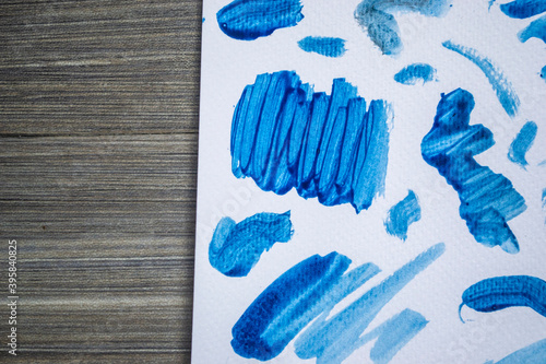 Blue watercolour squiggles on white watercolour paper