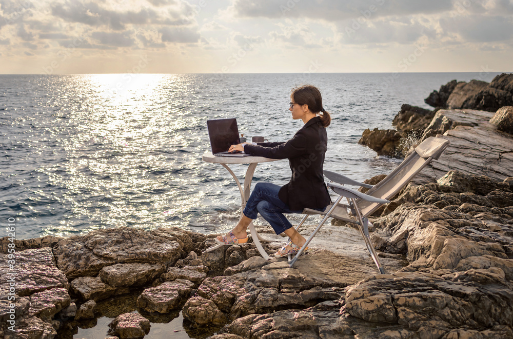 Business woman working from the beach. Working from distance concept. Freelancer travel and work online.