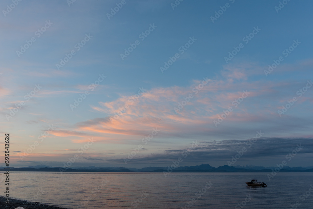 Fishing boats in the ocean at dusk off the coast of Bere Point, Sointula, Malcolm Island, British Columbia