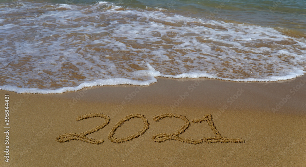 Fototapeta premium Happy new year 2021 written in the sand.Happy new year 2021 written in the sand by the sea.