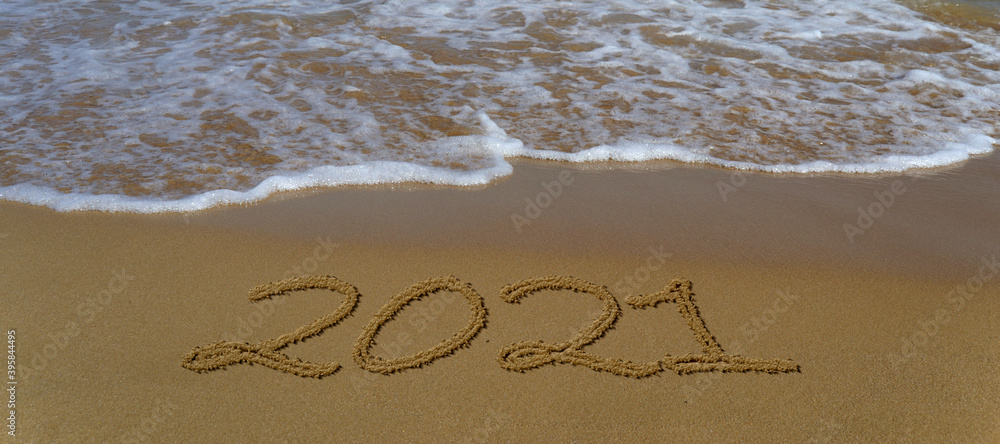 Fototapeta premium Happy new year 2021 written in the sand.Happy new year 2021 written in the sand by the sea.