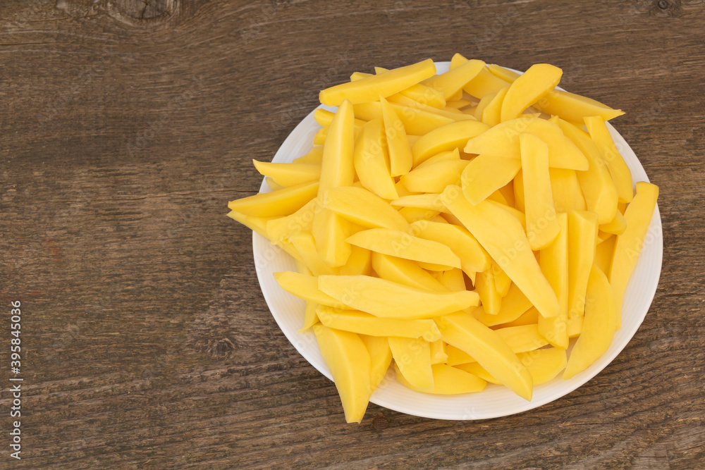 A plate full of sliced potatoes ready for baking A plate full of sliced potatoes ready for baking