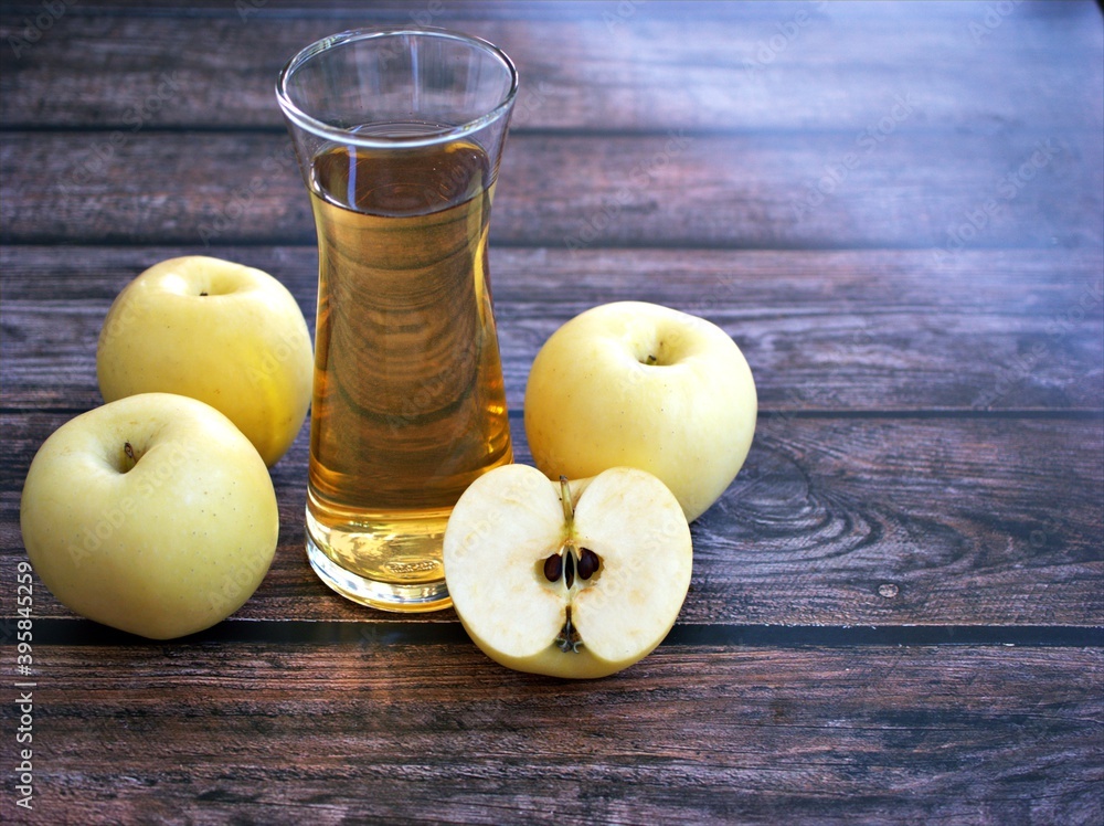 Apple juice and yellow apples fruit on wooden background Apple juice and yellow apples fruit on wooden background