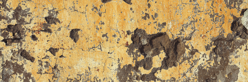 Concrete wall texture with cracked plaster. Weathered rough surface. Panoramic background for grunge design.