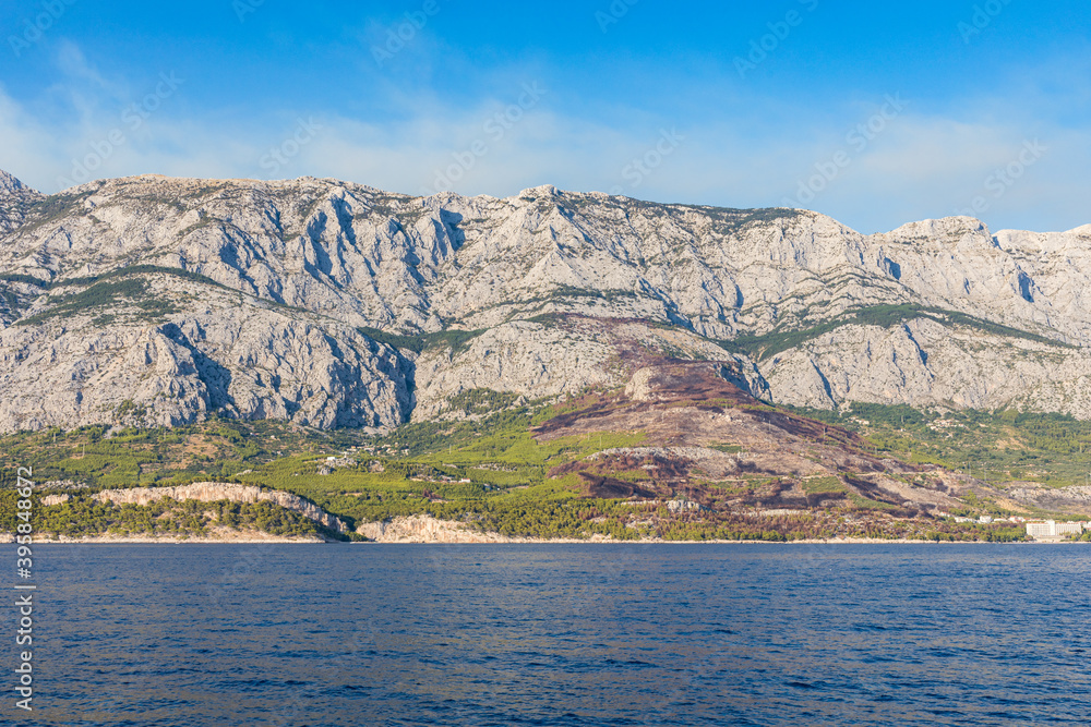 Blick aufs Meer vom Schiff in Kroatien. Welle und Berge mit Rauchwolken am Himmel. Panorama