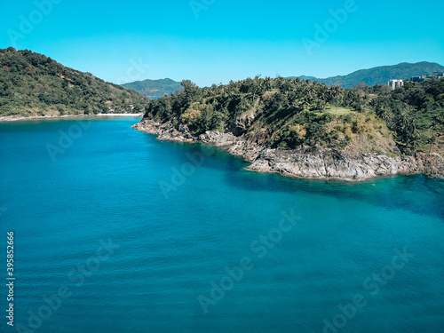 Fototapeta Naklejka Na Ścianę i Meble -  Top view of the beautiful coast of an isolated island around which clear blue water with inspiring waves
