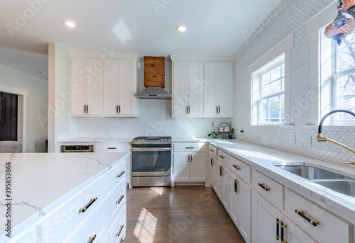 White quartz kitchen with cedar vent, windows, black and gold fixtures