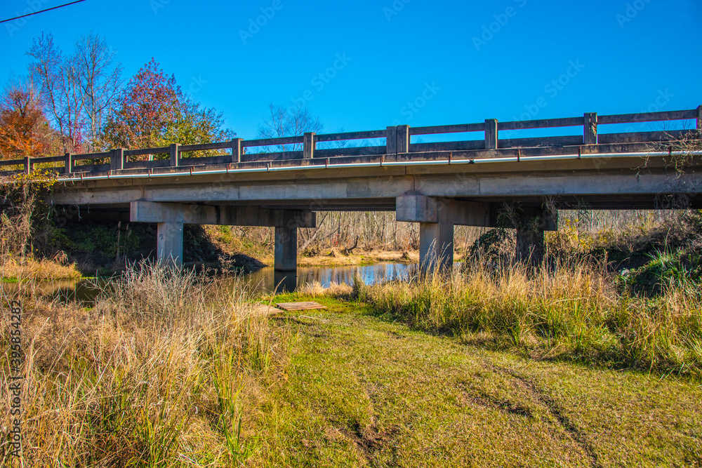 A river stream under a bridge and tire tracks in the south