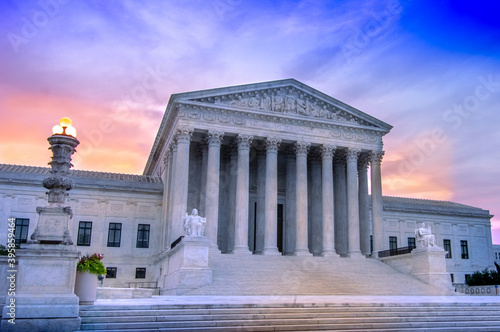 View of marble columns and greek classical architecture of the United States Supreme Court building with sunrise in background