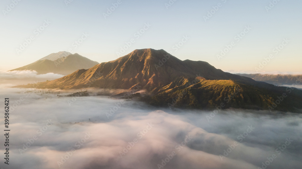 Aerial view of mount Batur volcano in Bali. Beautiful sunrise and low clouds. Panoramic view.
