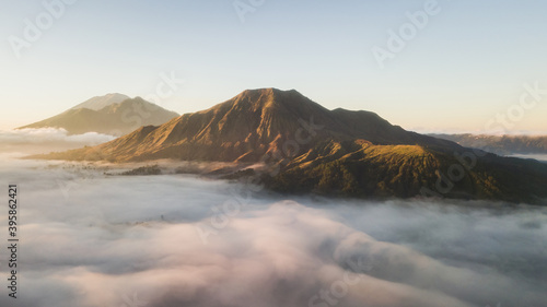 Aerial view of mount Batur volcano in Bali. Beautiful sunrise and low clouds. Panoramic view. © Oleg Breslavtsev