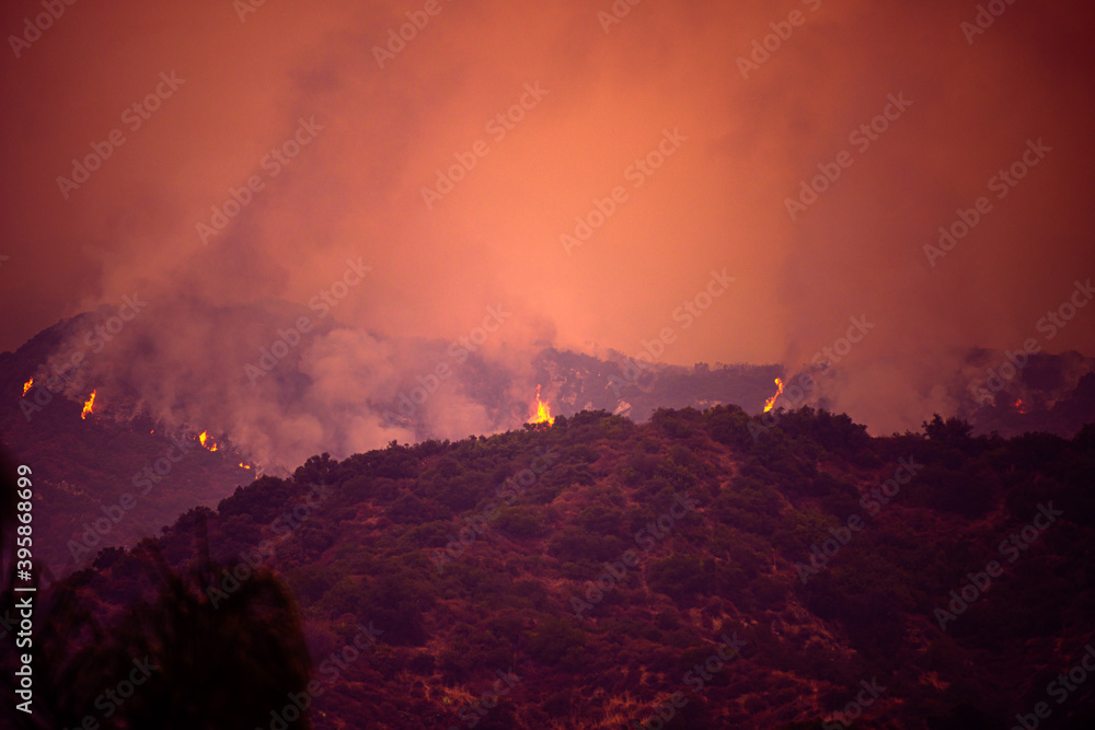 Fototapeta premium Fire and smoke in the mountains of California. Forest fires. Air Pollution. Toxic smoke. Fires in the United States. Climate change.