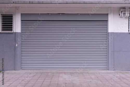 A closeup shot of automatic metal roller door used in factory, storage, garage, and industrial warehouse. The corrugated and foldable metal sheet offer space saving and provide urban and rustic feel