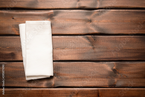 White towel on the brown wooden table background with copy space top view.