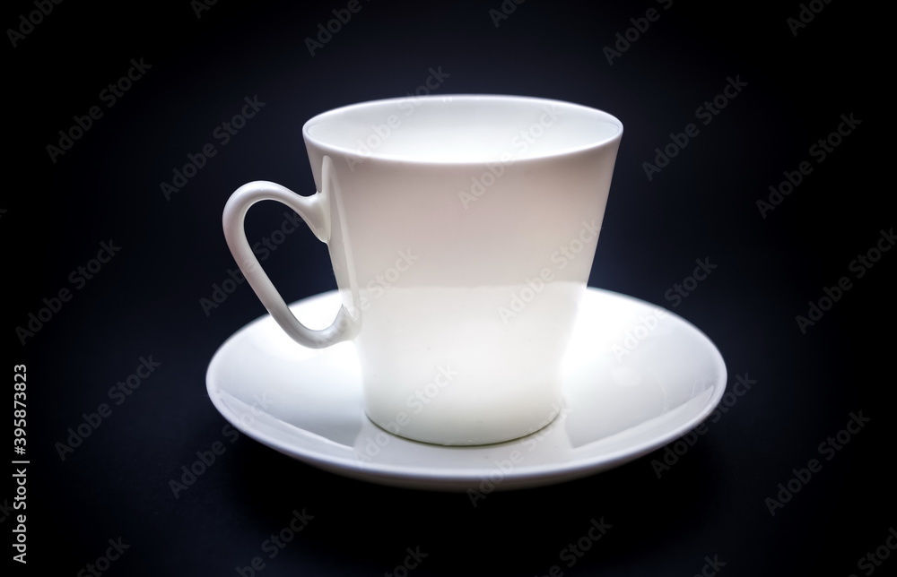White purchased porcelain coffee Cup with saucer closeup on black background