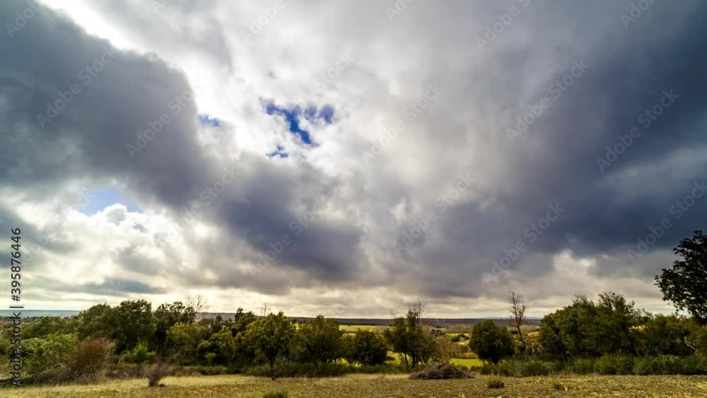 Timelapse nubes. Paisaje con cielo nublado y nubes corriendo rápido hacia cámara en campo con árboles y plantas. Timelapse nubes. Paisaje con cielo nublado y nubes corriendo rápido hacia cámara en campo con árboles y plantas.