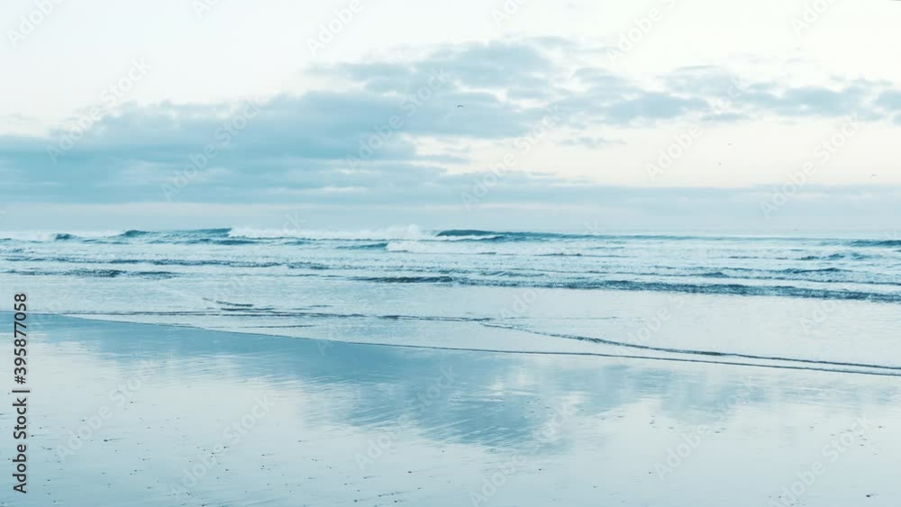 Morning beach scene with waves, cloudy sky, and reflections, sky blue. Meditative, calming SPA concept, background footage. Slow-motion. Morning beach scene with waves, cloudy sky, and reflections, sky blue. Meditative, calming SPA concept, background footage. Slow-motion.