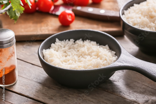 Bowl with boiled rice on table
