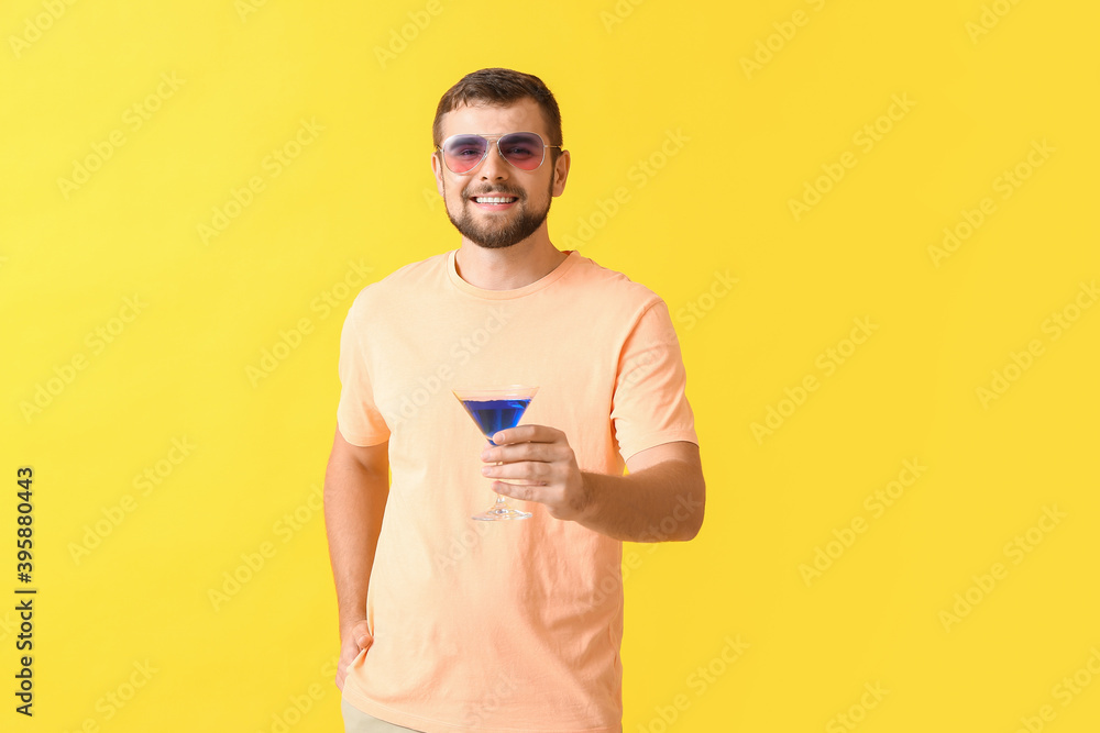 Handsome man with stylish sunglasses and cocktail on color background Handsome man with stylish sunglasses and cocktail on color background