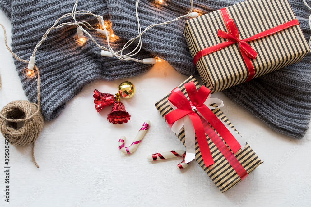 gift box for special in christmas and happy new year festival with decorate light cord , small bell , knitting wool scarf in winter season on background white wooden gift box for special in christmas and happy new year festival with decorate light cord , small bell , knitting wool scarf in winter season on background white wooden