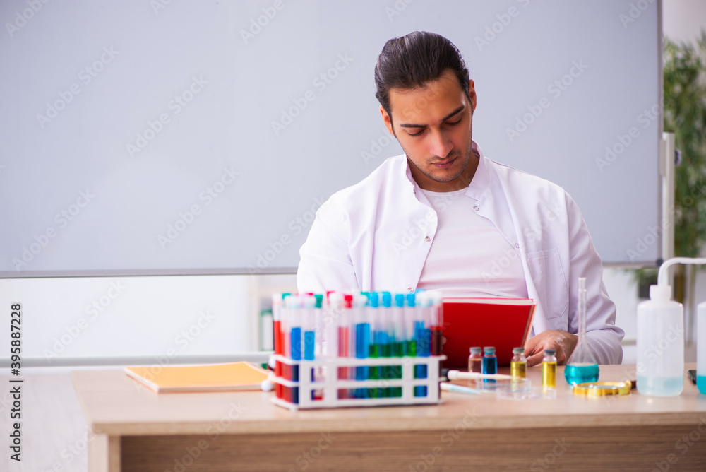 Young male chemistry teacher in the classroom Young male chemistry teacher in the classroom