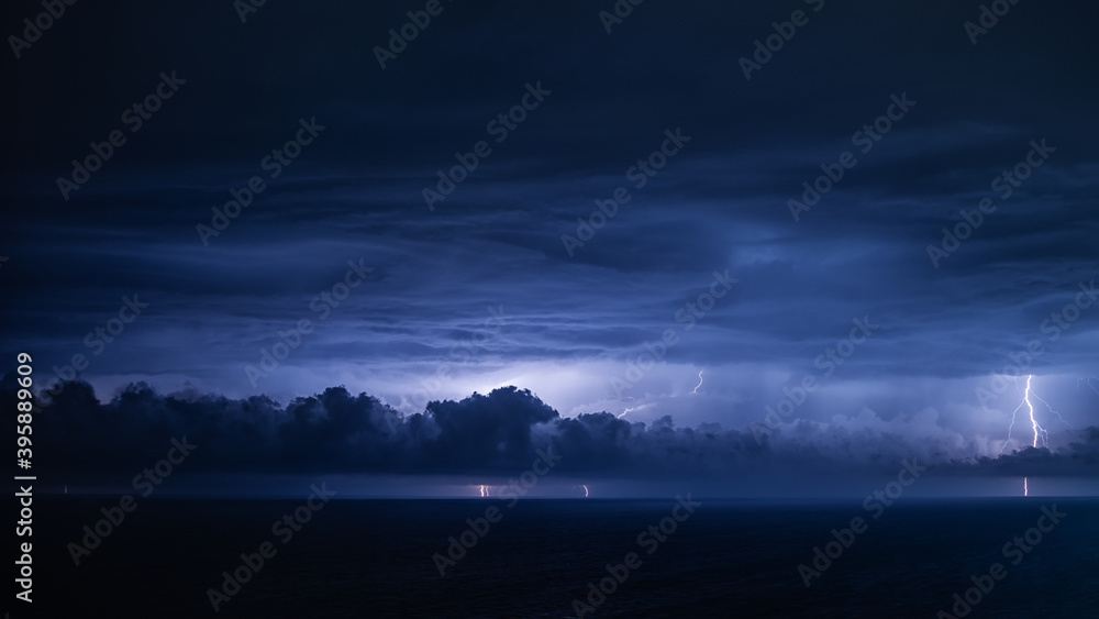 Night thunderstorm front over the sea with dramatic overcast sky, panoramic