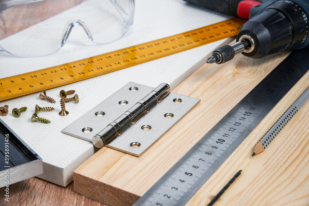 Installation of furniture hinges in the chipboard, tools and accessories needed to perform the work. Small carpentry work at home, the concept of a home master, self-repair of the house Installation of furniture hinges in the chipboard, tools and accessories needed to perform the work. Small carpentry work at home, the concept of a home master, self-repair of the house