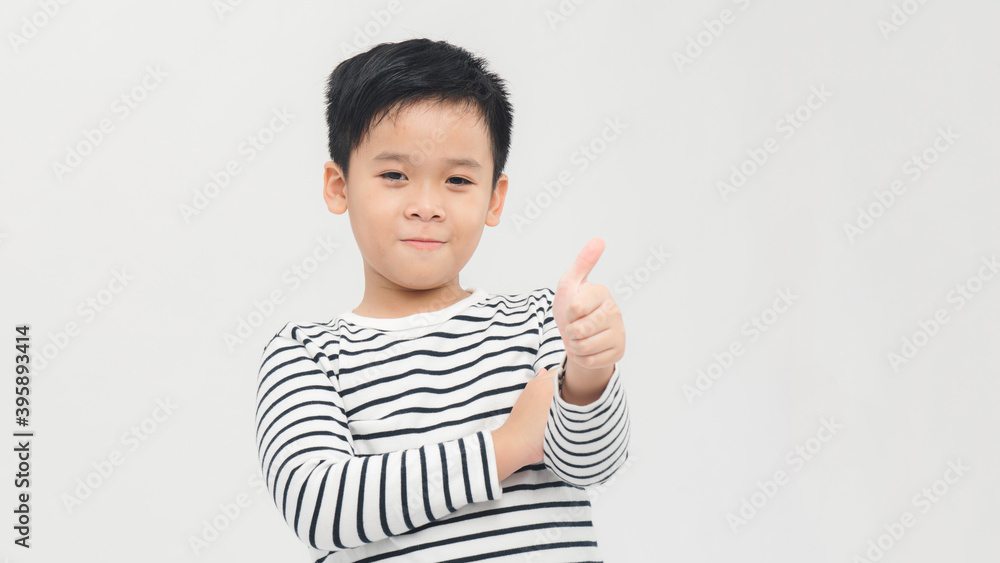 Portrait of happy boy showing thumbs up gesture, isolated over white background