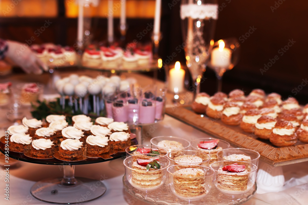 Catering table with sliced chocolate cakes decorated with fresh raspberries and nuts.