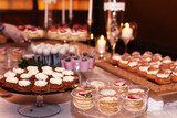 Catering table with sliced chocolate cakes decorated with fresh raspberries and nuts.