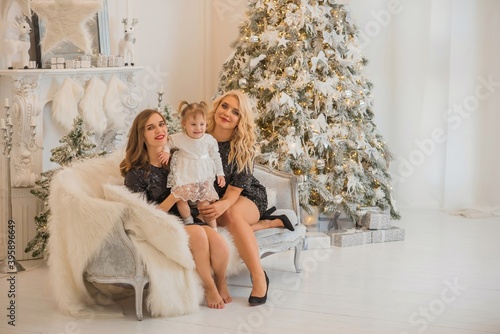 Christmas family scene, two women with a child, happy moms, New year time
