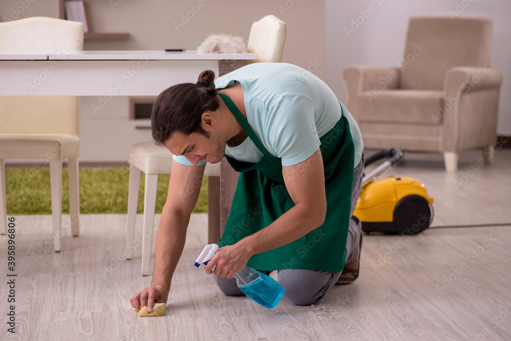 Young male contractor cleaning the house Young male contractor cleaning the house