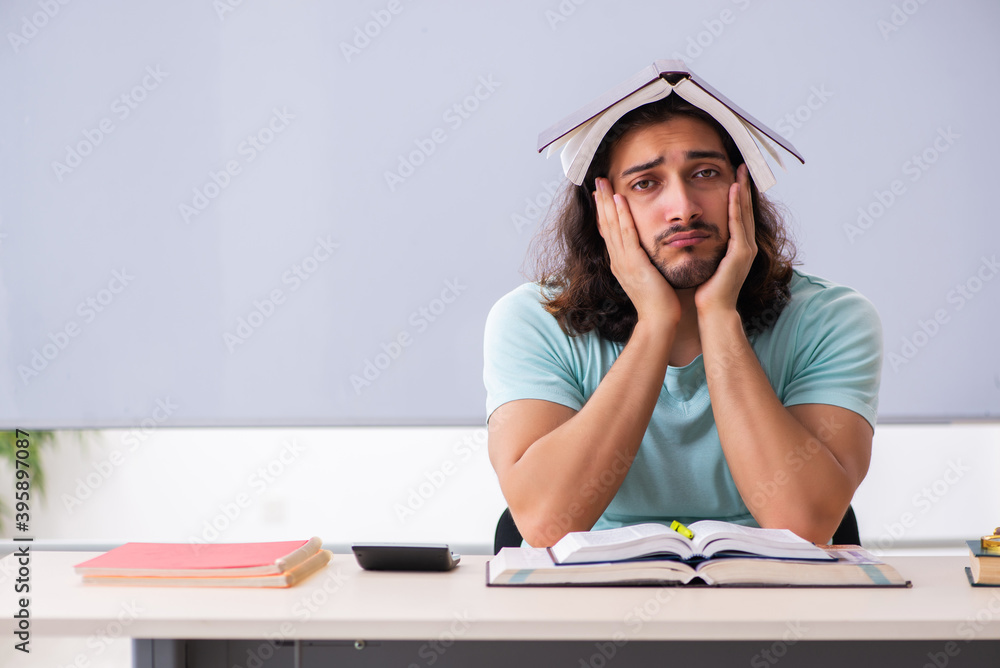 Young male student preparing for exams in the classroom Young male student preparing for exams in the classroom