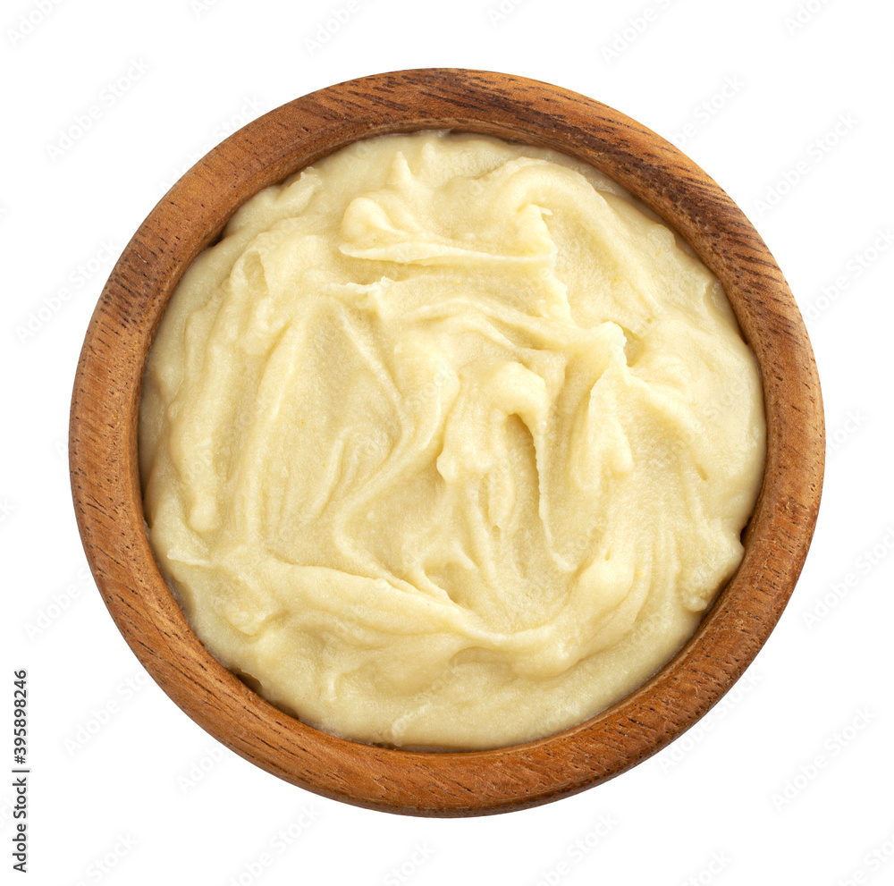 Mashed potato puree in wooden bowl isolated on white background, top view
