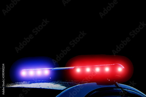 Police car with red and blue flashing lights on street at night time, crime scene. Emergency vehicle lights flashing.