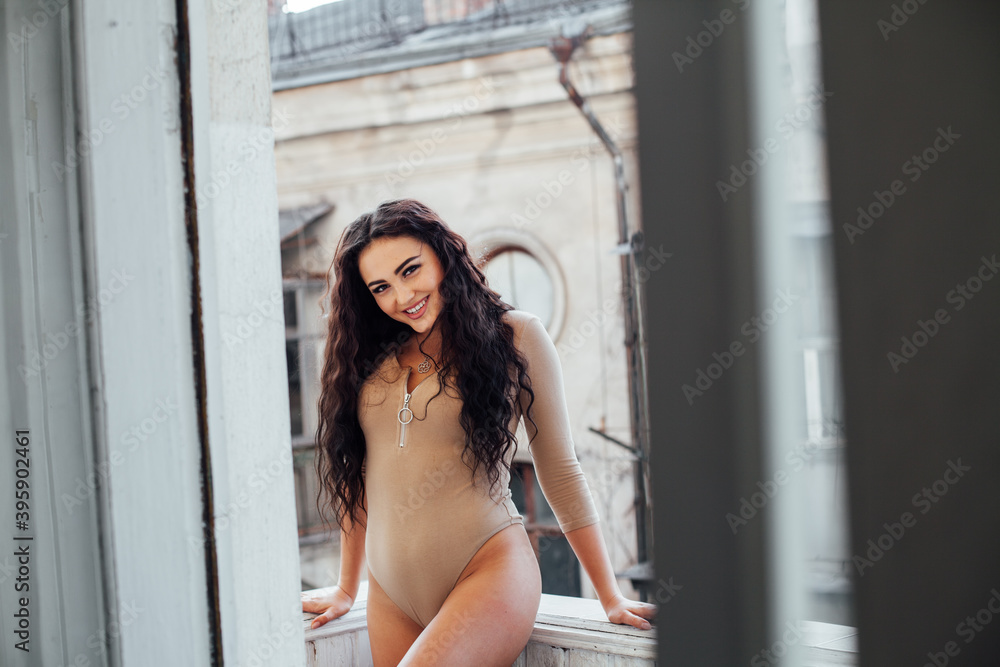 Portrait of a beautiful fashionable brunette woman in beige lingerie sits