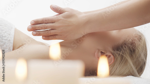 Young, beautiful and healthy woman in massaging salon. Traditional face massage therapy and skin care.