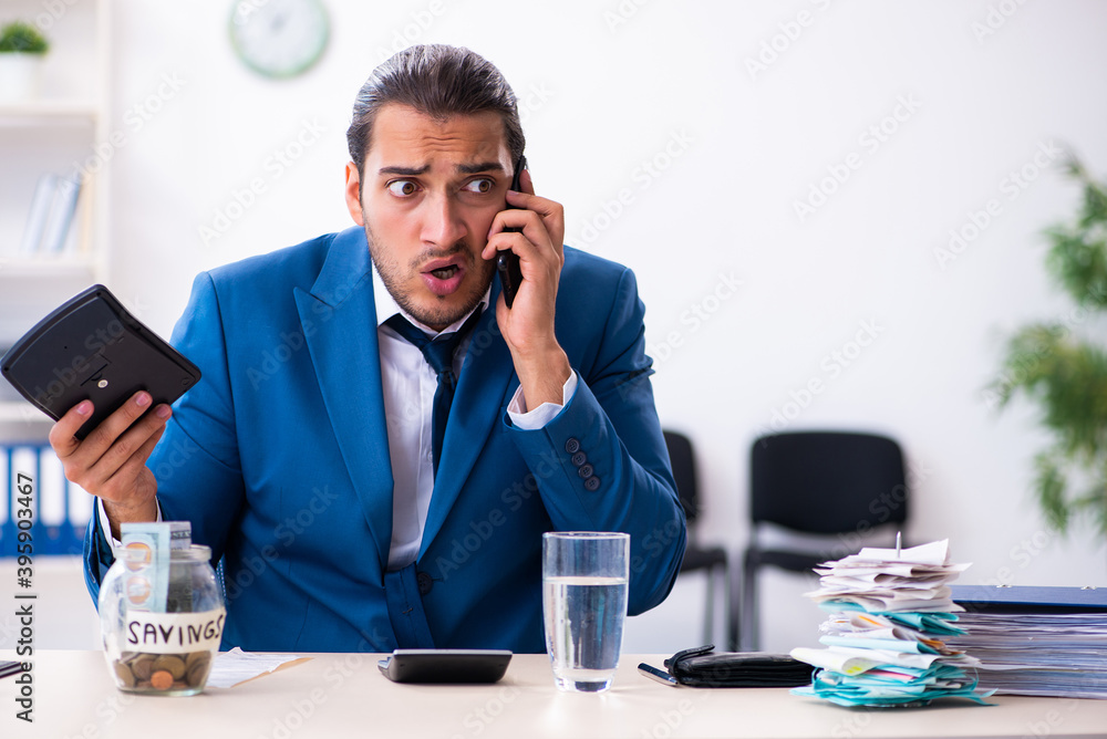 Young male accountant in budget planning concept Young male accountant in budget planning concept