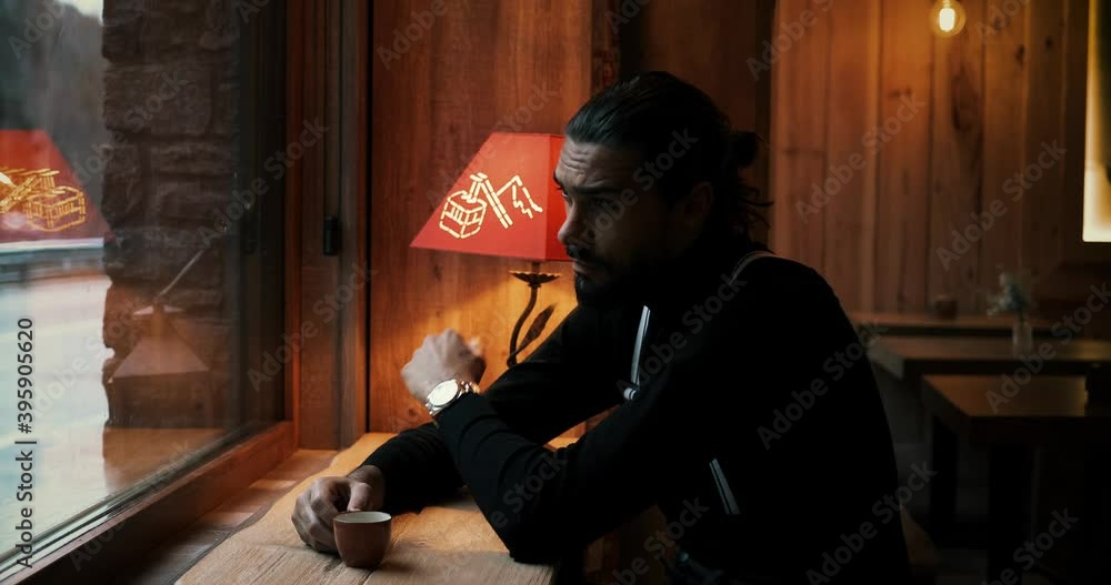 Man drinking coffee in a coffee shop. He looks outside the window and he coss his fingers 4K Man drinking coffee in a coffee shop. He looks outside the window and he coss his fingers 4K